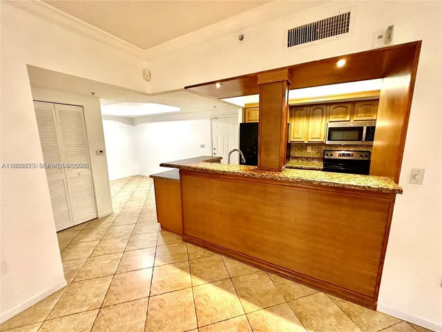 a living room with stainless steel appliances kitchen island granite countertop a sink and cabinets