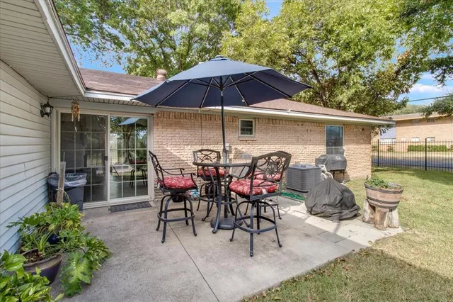 a view of a patio with table and chairs under an umbrella