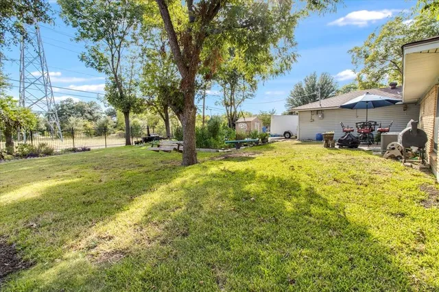 a view of a backyard with table and chairs under an umbrella