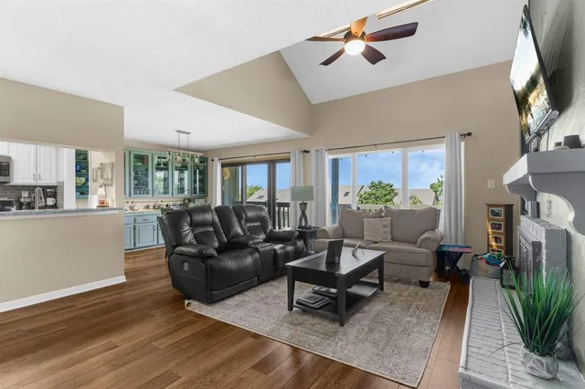 a living room with furniture a fireplace a potted plant and a large window