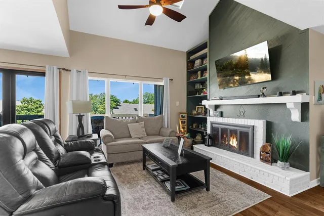 a living room with furniture a flat screen tv and a fireplace