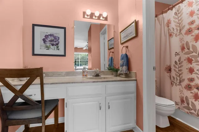 a bathroom with a granite countertop sink a toilet and a mirror