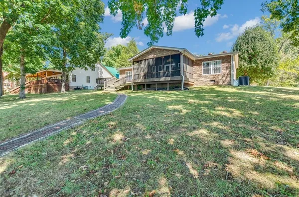 a view of a house with a big yard plants and large trees