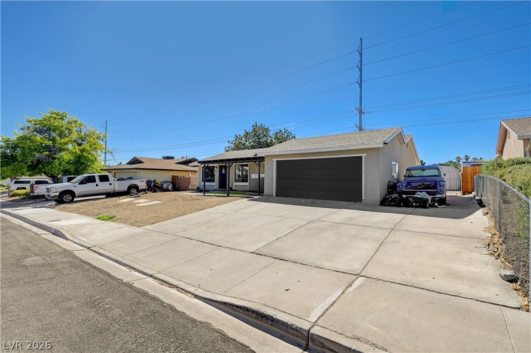 1331 Pinto Road Boulder City, NV 89005 - Photo 8 of 46 A classic ranch home features a wide concrete driveway leading to an attached garage.