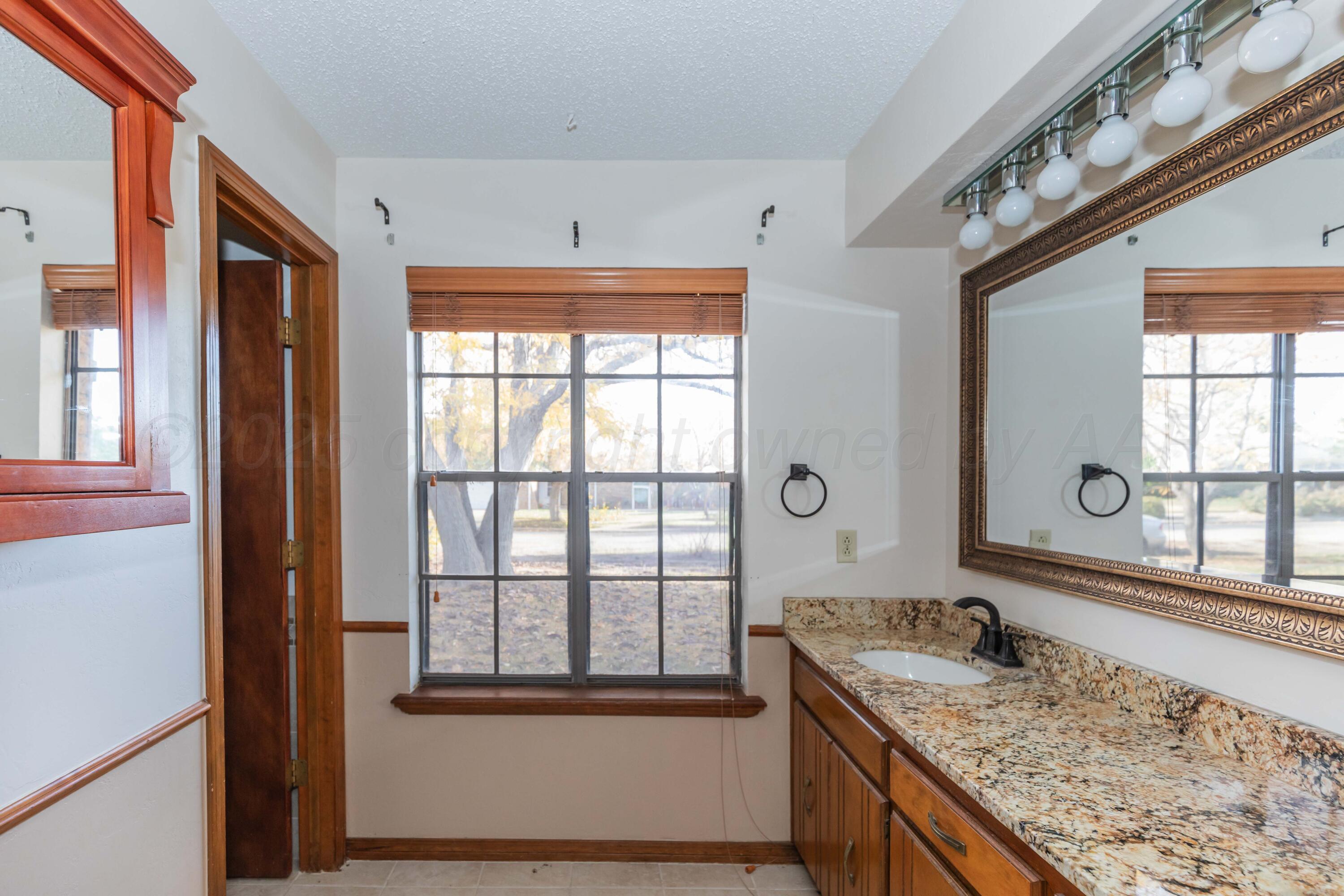 7805 Farrell Drive Amarillo, TX 79121 - Photo 14 of 20 a bathroom with a granite countertop sink and large window