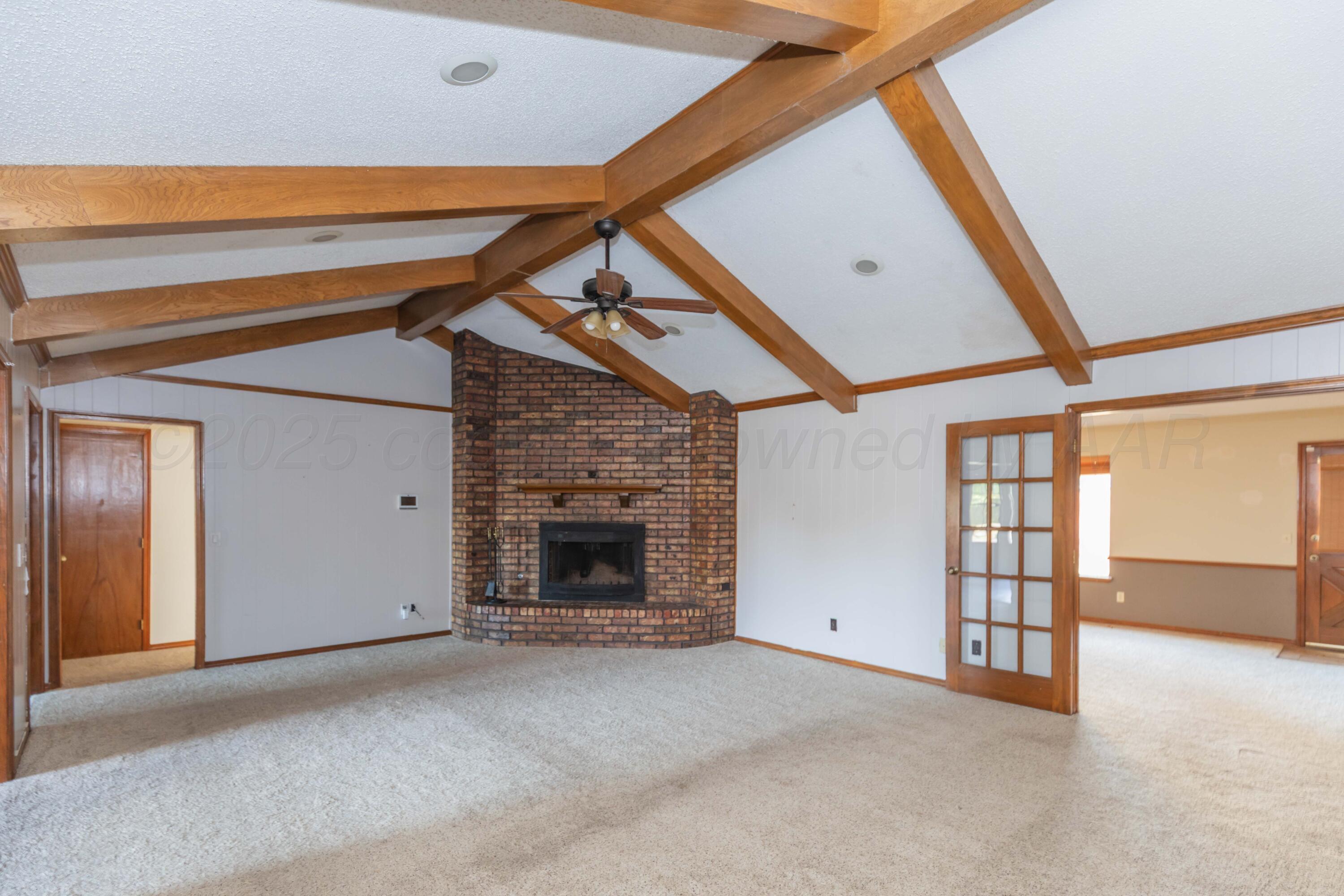 7805 Farrell Drive Amarillo, TX 79121 - Photo 3 of 20 a view of an empty room with a fireplace and a window