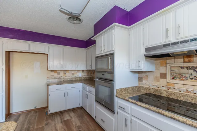 a kitchen with stainless steel appliances granite countertop a sink stove and cabinets