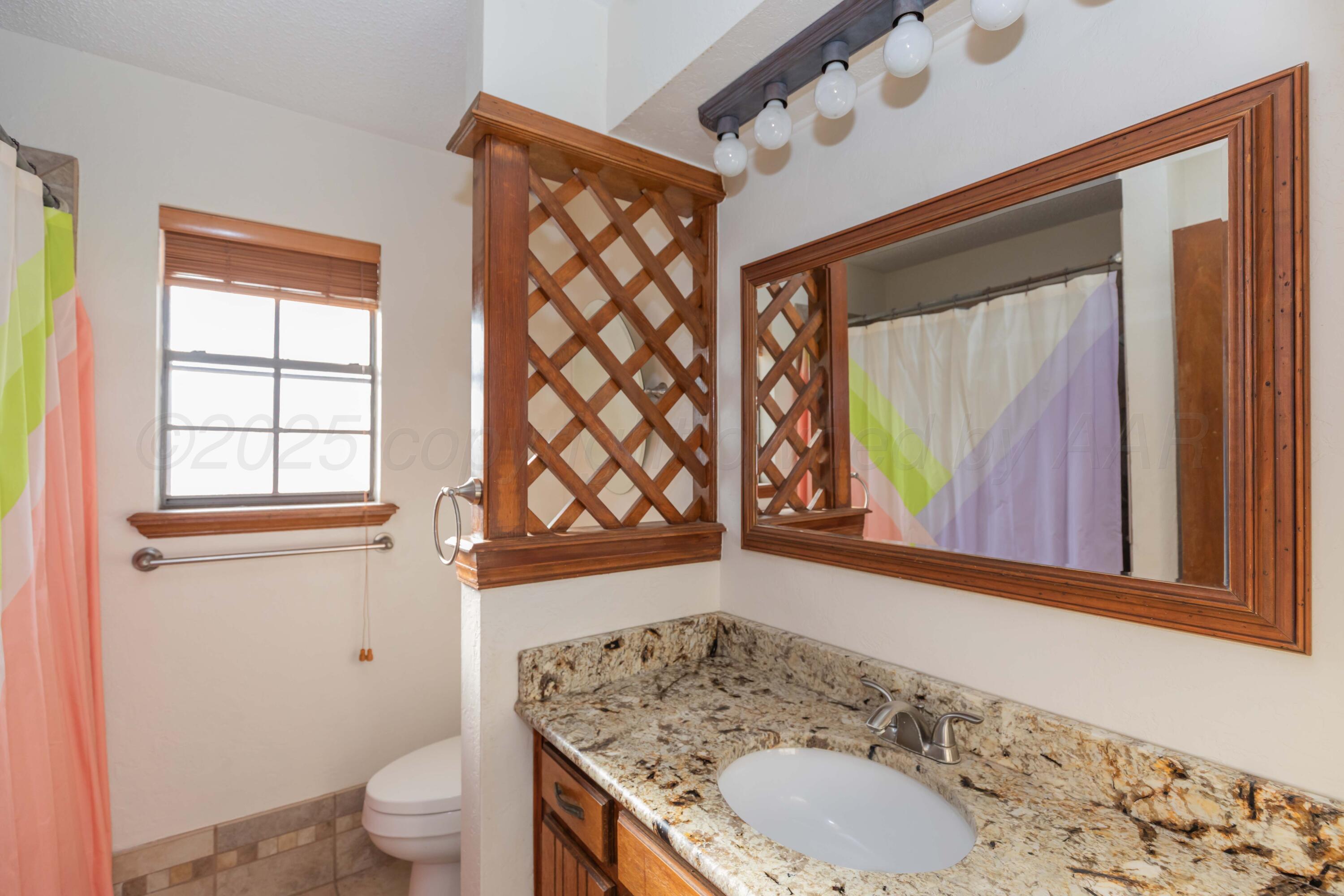 7805 Farrell Drive Amarillo, TX 79121 - Photo 10 of 20 a bathroom with a granite countertop sink toilet and shower