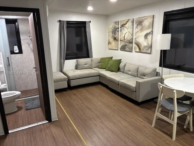 a living room with furniture and a wooden floor