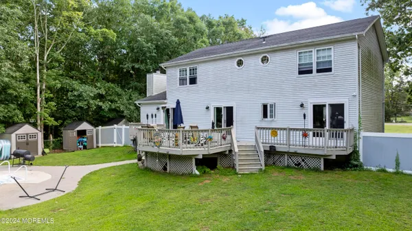 a view of house with a backyard and deck