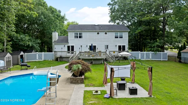 a view of a house with backyard swimming pool and sitting area