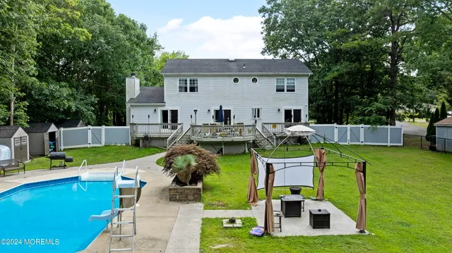 a view of a house with backyard swimming pool and sitting area