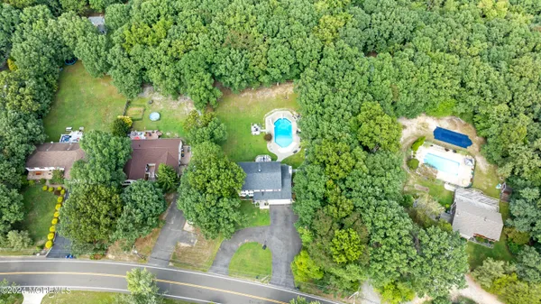 an aerial view of a house with swimming pool and garden space