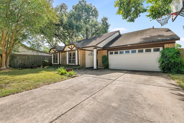 a front view of house with yard and trees around