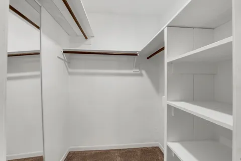 a view of walk in closet with empty racks