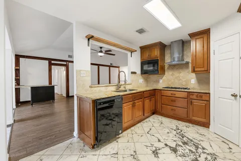a kitchen with stainless steel appliances granite countertop a sink stove and cabinets