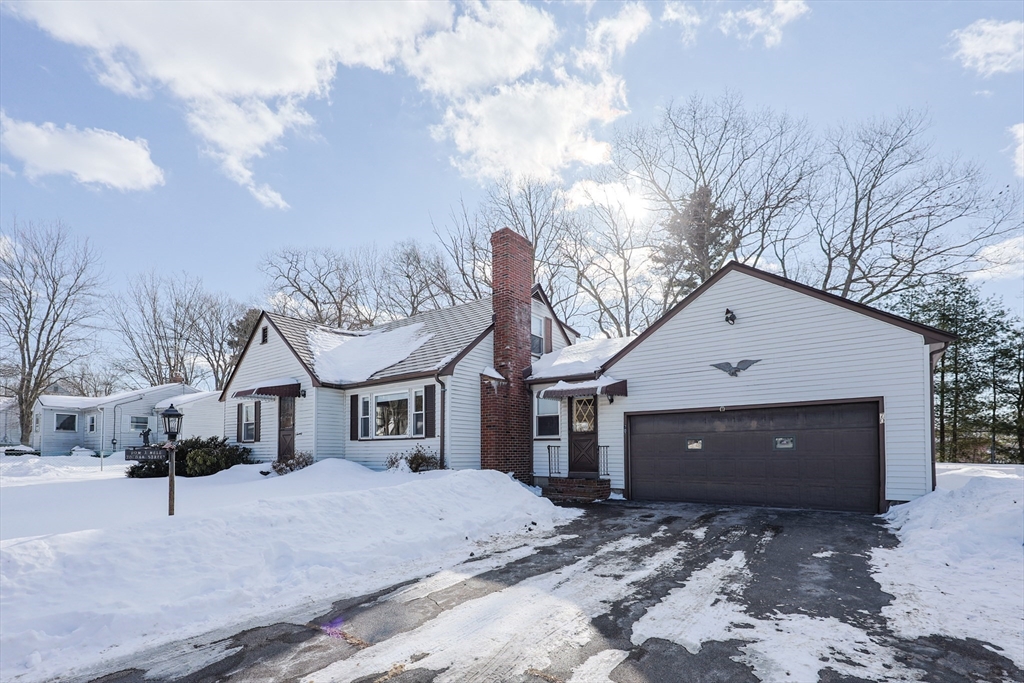 a front view of a house with a yard covered in snow
