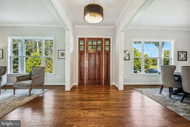a kitchen with stainless steel appliances granite countertop a stove a sink and white cabinets with wooden floor