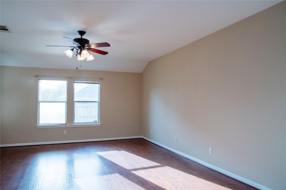 3936 Links Lane Round Rock, TX 78664 - Photo 16 of 40 an empty room with wooden floor chandelier fan and windows