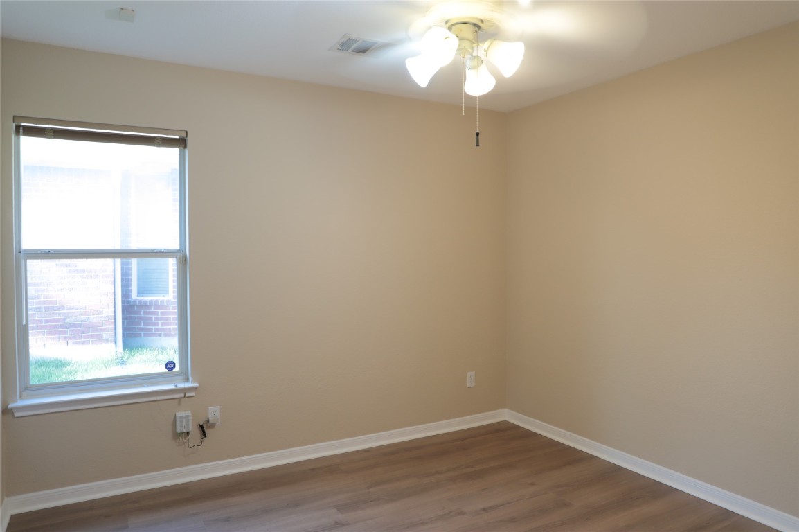 3936 Links Lane Round Rock, TX 78664 - Photo 30 of 40 an empty room with wooden floor and windows