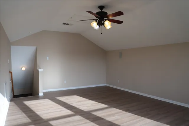 a view of a room with a chandelier fan and a window