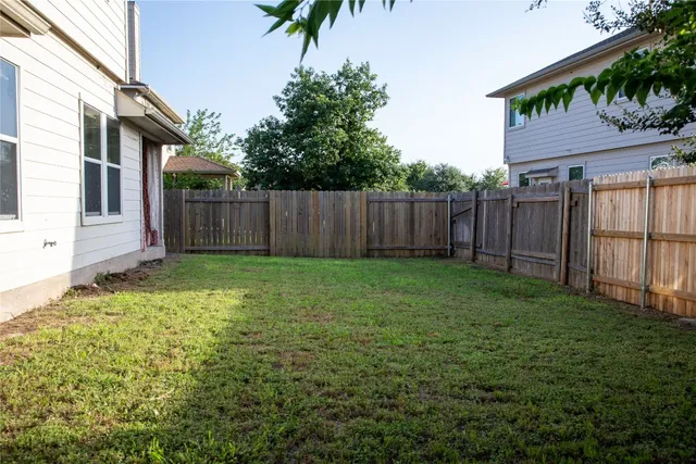 a view of backyard with potted plants and wooden fence