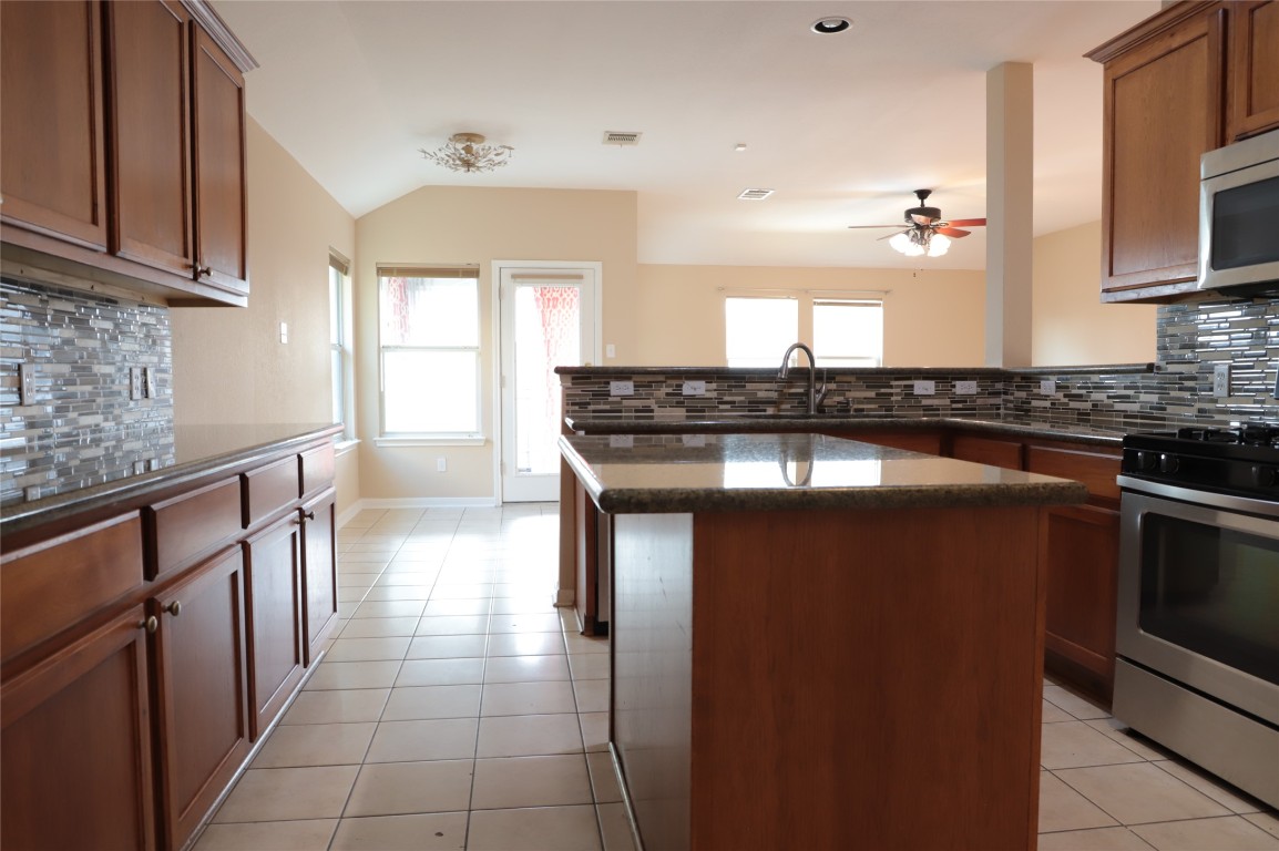 3936 Links Lane Round Rock, TX 78664 - Photo 5 of 40 a kitchen with stainless steel appliances granite countertop a sink and a stove