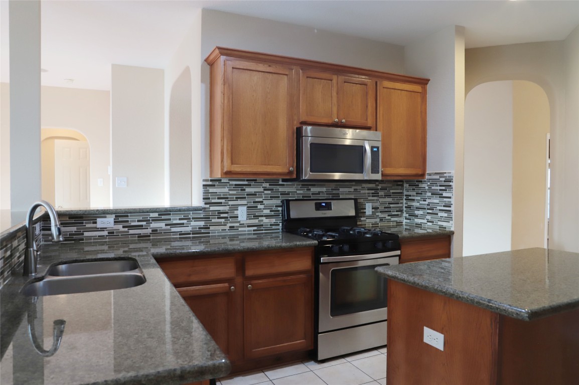 3936 Links Lane Round Rock, TX 78664 - Photo 7 of 40 a kitchen with a sink stove and microwave