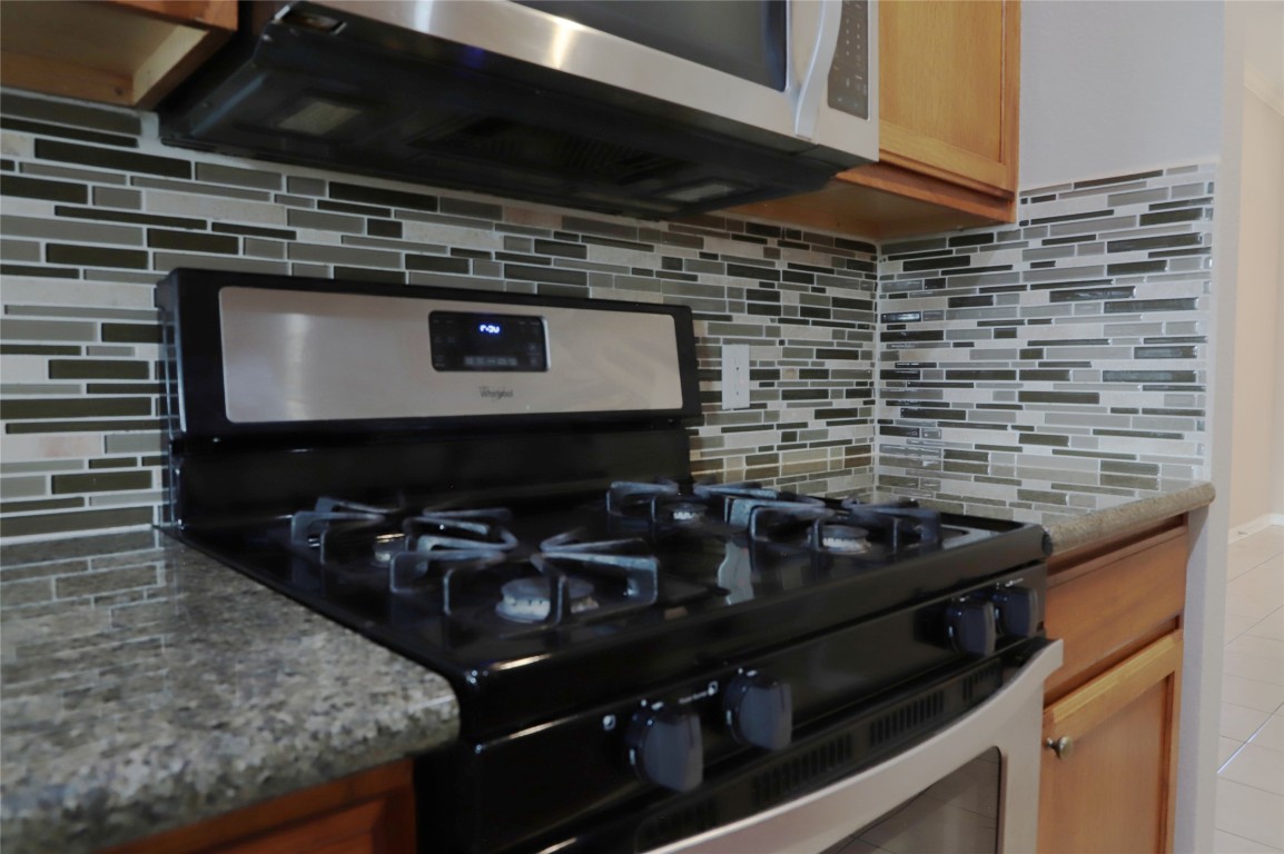 3936 Links Lane Round Rock, TX 78664 - Photo 8 of 40 a kitchen with a stove and a microwave