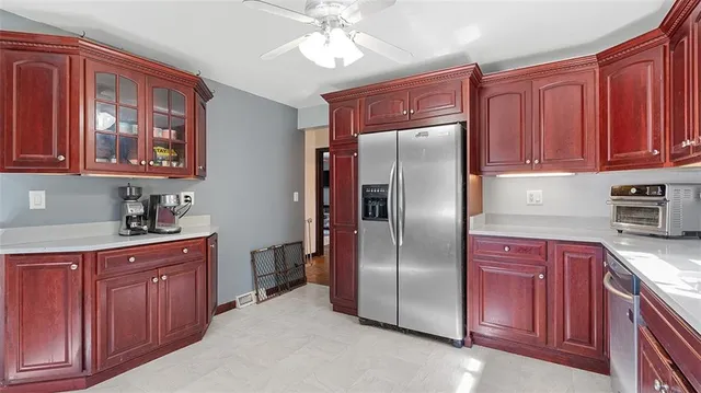 a kitchen with stainless steel appliances granite countertop a refrigerator a sink dishwasher and wooden cabinets