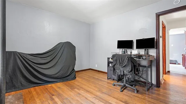 a view of a workspace with wooden floor and furniture
