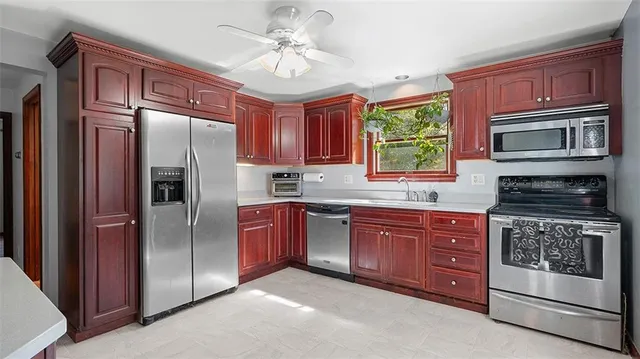 a kitchen with stainless steel appliances granite countertop a refrigerator a stove a sink and dishwasher