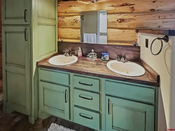 a bathroom with a granite countertop double vanity sink and a mirror