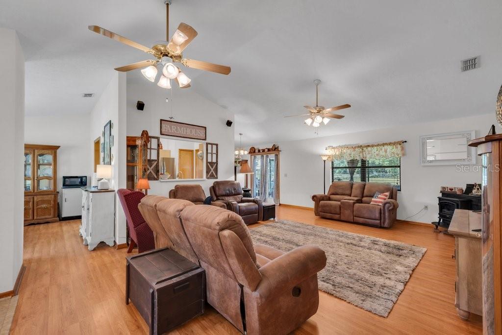 5301 Coronet Road Plant City, FL 33566 - Photo 20 of 38 a living room with furniture a chandelier and a wooden floor