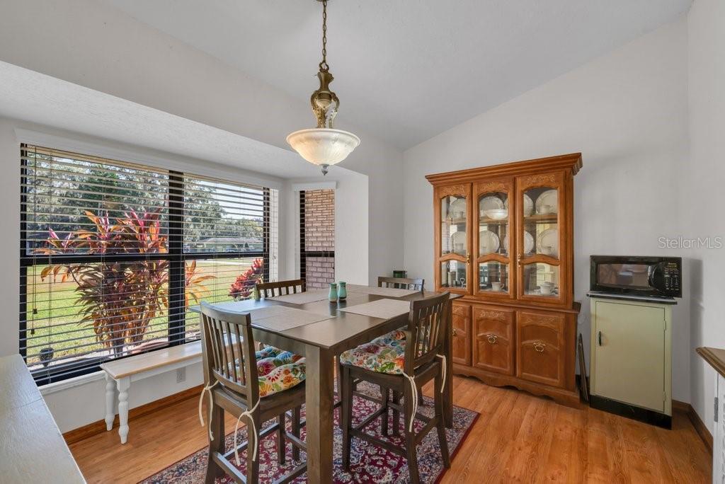 5301 Coronet Road Plant City, FL 33566 - Photo 23 of 38 a view of a dining room with furniture large windows and wooden floor
