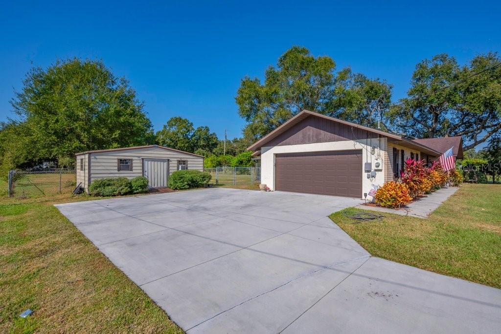 5301 Coronet Road Plant City, FL 33566 - Photo 35 of 38 a front view of a house with a yard and a garage