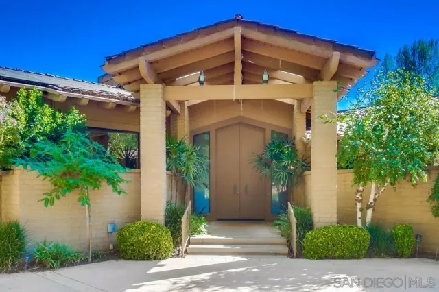 a front view of a house with plants