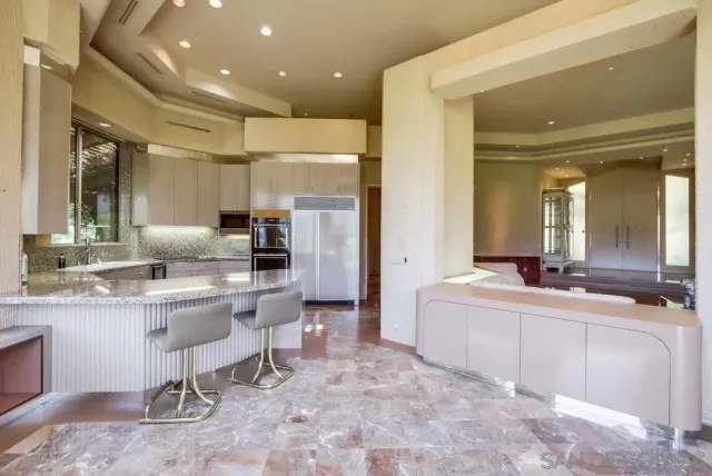 a kitchen with stainless steel appliances granite countertop a sink and a refrigerator