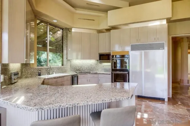 a kitchen with stainless steel appliances granite countertop a refrigerator and a sink