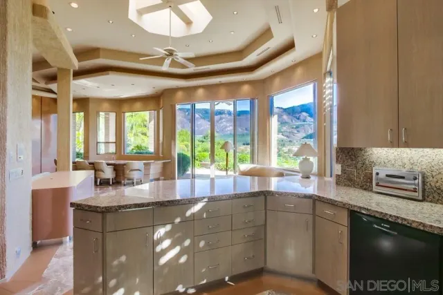 a large kitchen with kitchen island granite countertop a sink and a stove