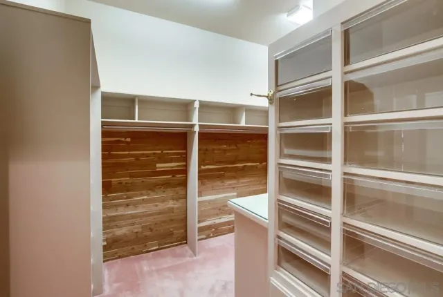 a view of walk in closet with empty racks