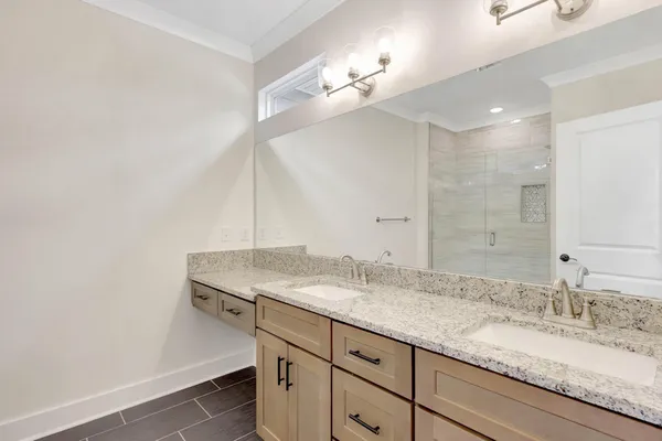 a bathroom with a granite countertop sink a light fixture and a mirror