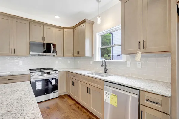 a kitchen with stainless steel appliances granite countertop a sink a stove and a microwave