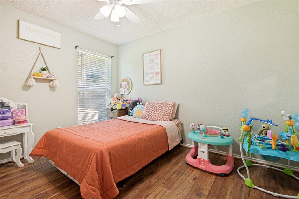 7410 Jessica Way Rowlett, TX 75088 - Photo 16 of 25 a bedroom with a bed and a chandelier