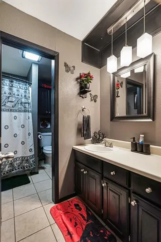 a bathroom with a granite countertop toilet and a sink