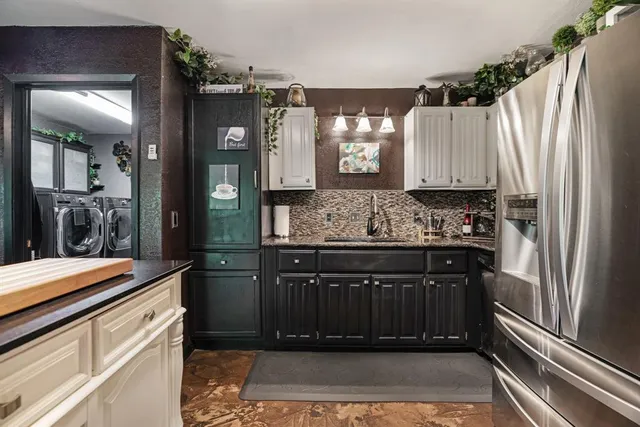 a kitchen with stainless steel appliances granite countertop a refrigerator and a stove