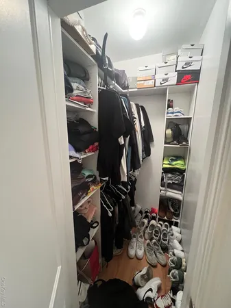 a view of walk in closet with clothes and shoes