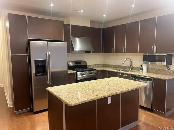 a kitchen with kitchen island a counter top space cabinets and stainless steel appliances