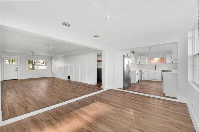 a view of a kitchen with wooden floor and a refrigerator