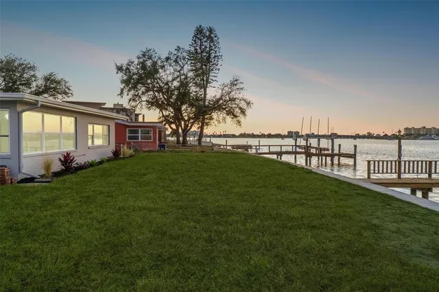 a view of a house with a big yard next to a lake